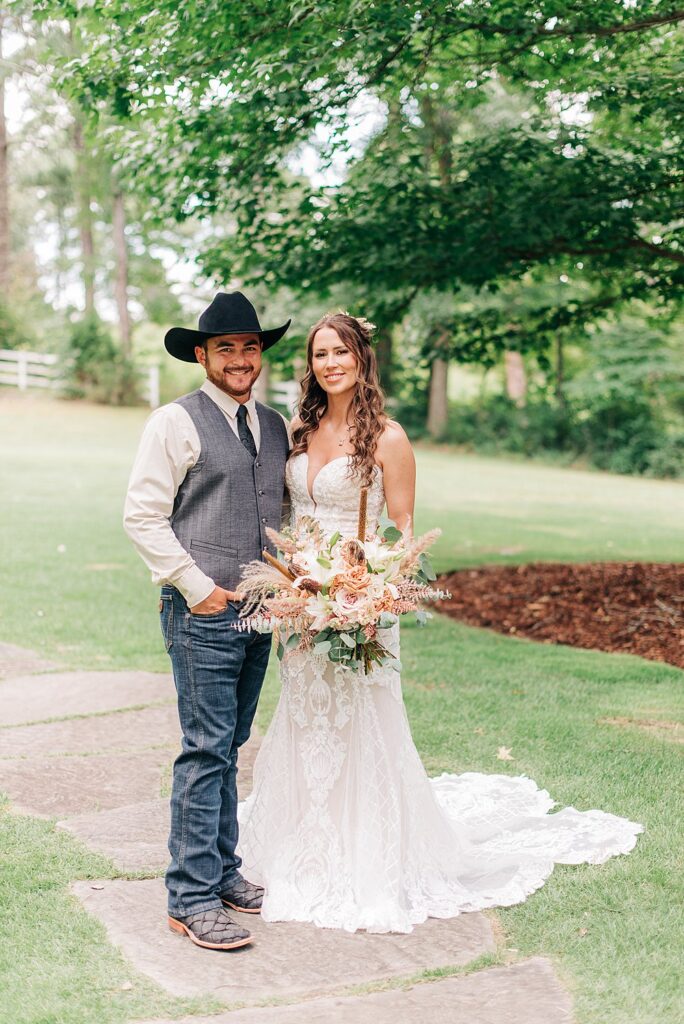 bride and groom posed outside on lawn at The Barn At Shady Lane wedding venue